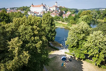 Der Bootsübernachtungsplatz liegt idyllisch an der Donau umgeben von Bäumen. Man hat Blick auf das Schloss und die Altstadt.