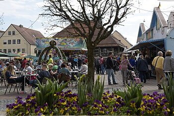 Frühjahrsdult belebter Schrannenplatz hinter Blumenbeet