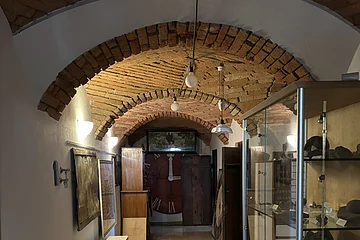 In einem gemauerten Gewölbe stehen Vitrinen mit Exponaten an den Wänden